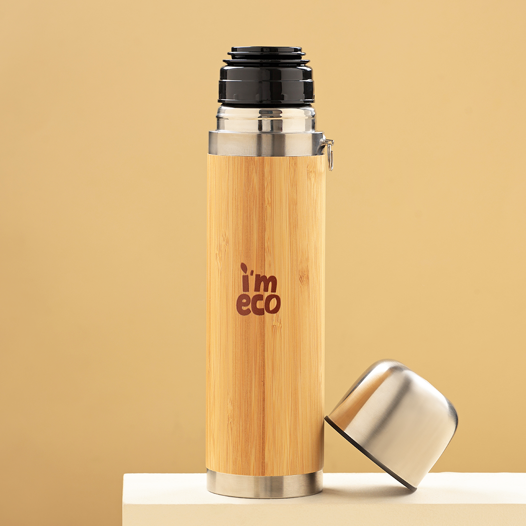 Bamboo thermos flask is placed on a white surface with its lid open.