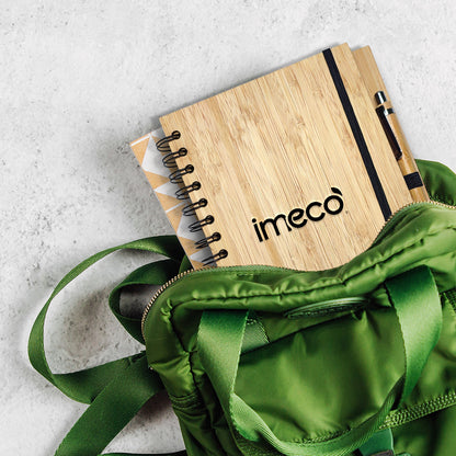 imeco bamboo notebook with imeco branding on a green bag against a light gray background