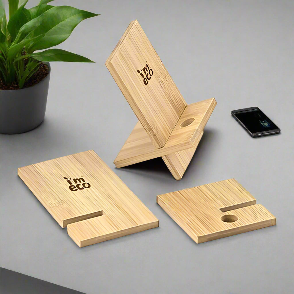 Two IMECO Bamboo Mobile Stands are there. One is assembled and one disassembled, placed on a white surface there is a phone and flower pot