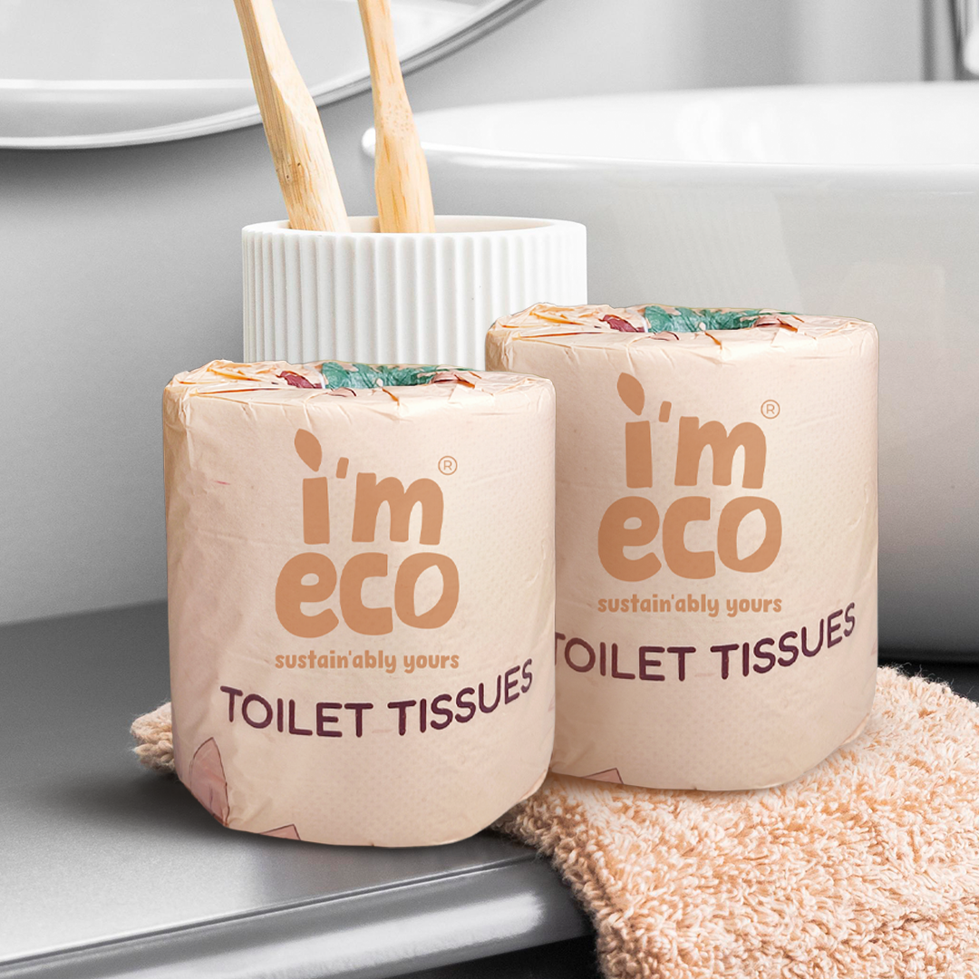 Two packs of IMECO Toilet Tissues placed on bathroom slab on a soft cloth against a white background
